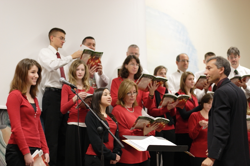 Il direttore del coro e una cantante in primo piano