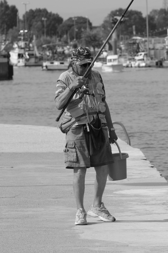 Un pescatore,in riva al molo