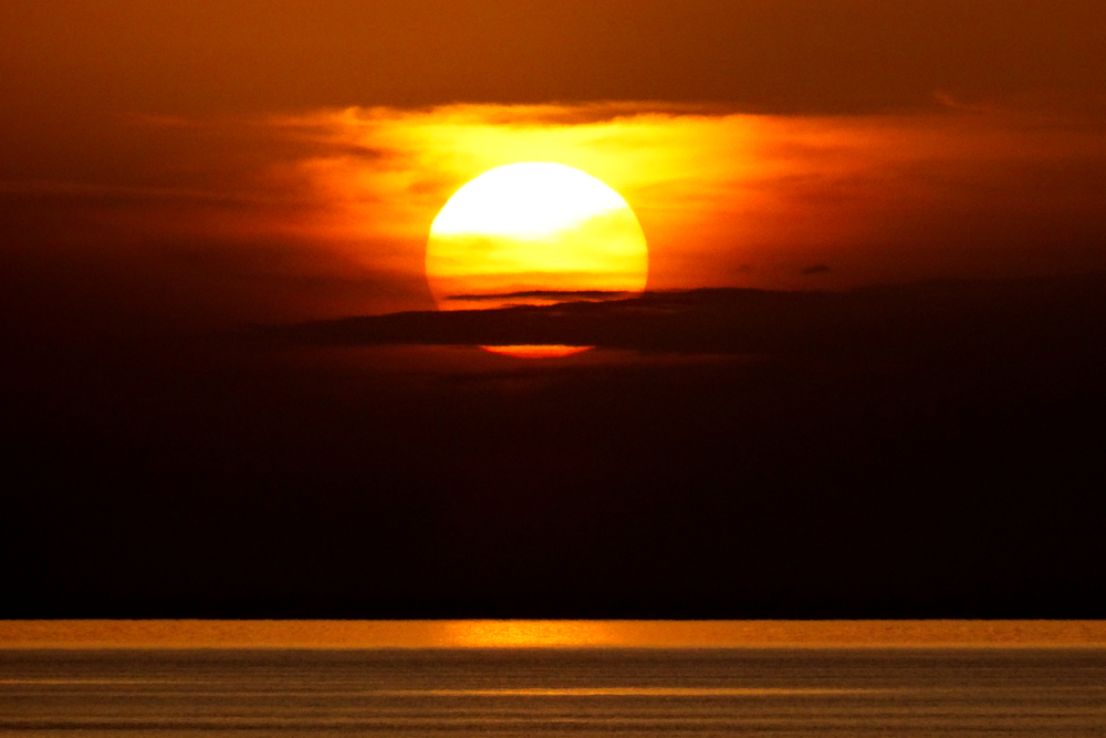 Sole tra nubi scure al tramonto