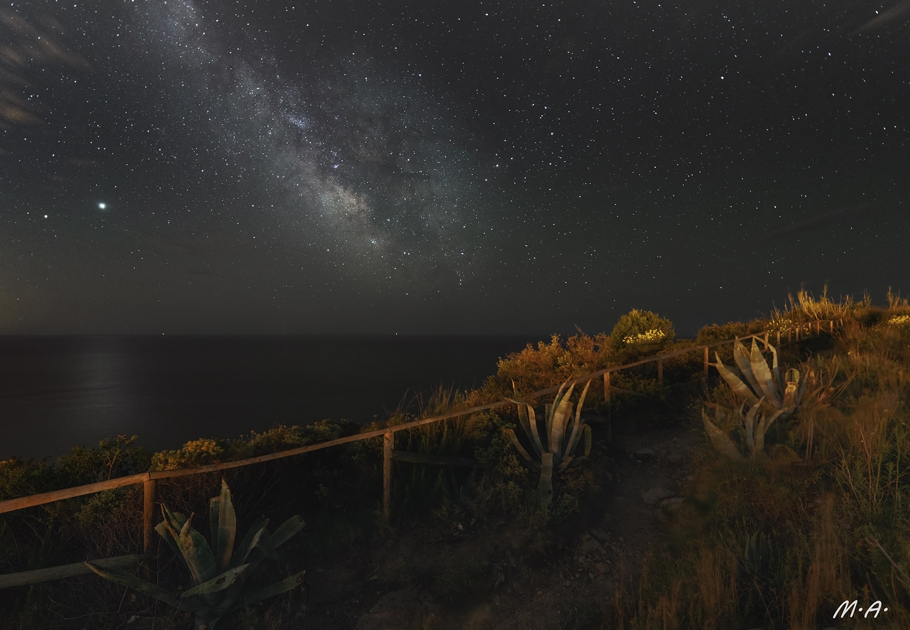 Via lattea con Giove e Saturno sul mare