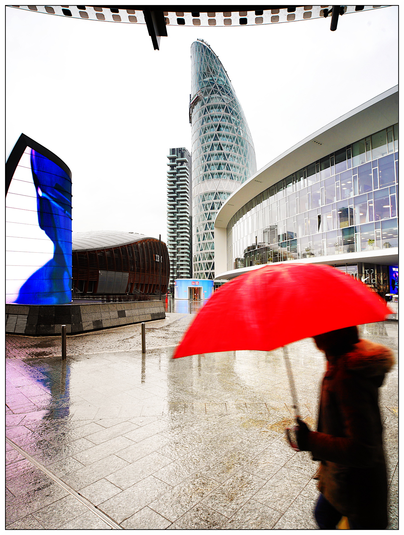 passante con ombrello in Piazza Gae Aulenti
