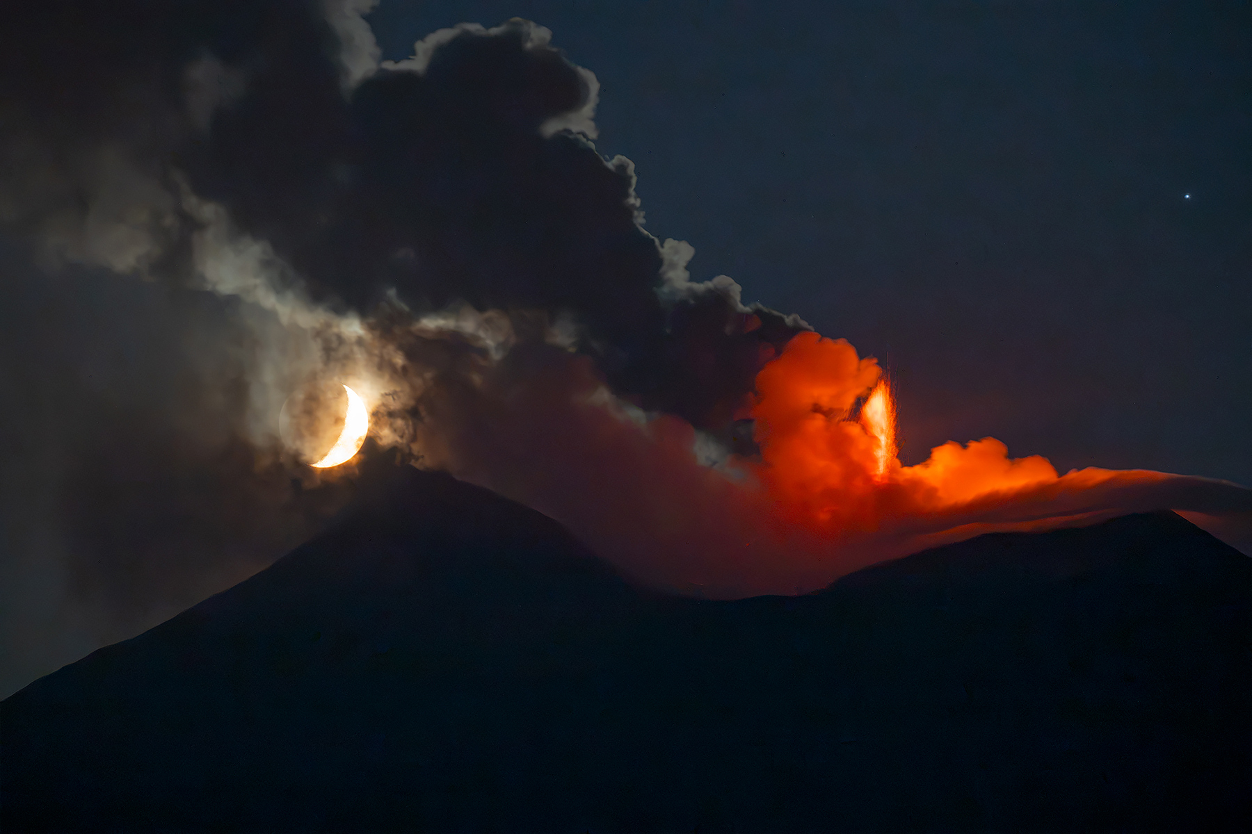 La luna ed il vulcano in eruzione