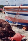 olympus om 10, zuiko 50 mm. paint shop pro, neat image. Spiaggia di Falcone - Messina, Il rosso della barca, della rete e della piccola boa animano l'immagine ed attirano il fotografo